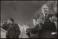 Senator Eugene McCarthy applauds the priest at the podium during the Unity Day Rally hosted in the Mayflower Hotel, Washington, D.C., 10 November 1968
