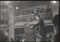 A priest delivers an address from behind a podium at the Unity Day Rally hosted in the Mayflower Hotel, Washington, D.C., 10 November 1968