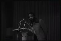 Close-up of Dick Gregory looking out on the crowd as he speaks to students at American University, Washington, D.C., 16 February 1969