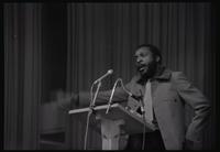 Dick Gregory gives an address from onstage in an auditorium at American University, Washington, D.C., 16 February 1969