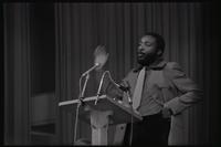 Dick Gregory waves his hand while addressing a crowd of students at American University, Washington, D.C., 16 February 1969