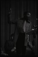 Dick Gregory gestures upwards while delivering an address to American University students in the Leonard Center, Washington, D.C., 16 February 1969