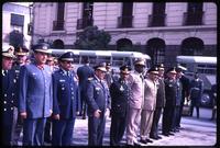 Military personnel standing near military academy and buses