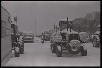 Tractors, one displaying a sign that says "Damn right this trip is necessary 100%," park on the National Mall in participation with the American Agriculture Movement's second Tractorcade demonstration in Washington, D.C., 28 February 1979