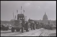 A parade of tractors drives along snowy Pennsylvania Avenue near the U.S. Capitol Building during the American Agriculture Movement's second Tractorcade demonstration in Washington, D.C., 28 February 1979