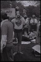A costumed man wearing a "Human error" shirt holds a bumper sticker that reads "Honk if you have fission" behind the merchandise table at the anti-nuclear power demonstration in Washington, D.C., 06 May 1979