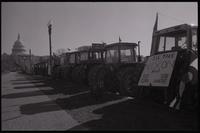 A line of tractors, displaying protest signs and flags, parked along Pennsylvania Avenue near the U.S. Capitol Building during the first Tractorcade demonstration in Washington, D.C., 18 January 1978