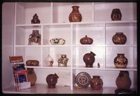 Shelved pottery behind "Hotelito" front desk