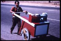 Peddler pushing cart in street 