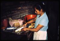 Woman cutting plantains in kitchen 