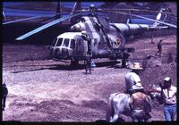 Close view of Mil Mil-8 helicopter landing and man on horse in foreground
