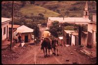 Man with horses on unpaved road in Yalí
