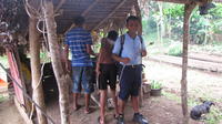 Boys stand by a fire roasting marshmallows for s'mores, El Plátano, Panama