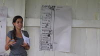 Aminda standing next to a farming schedule at an agribusiness seminar in Bocas del Toro, Panama