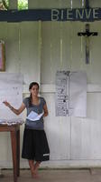Alternate view of Aminda standing next to a farming schedule at an agribusiness seminar in Bocas del Toro, Panama