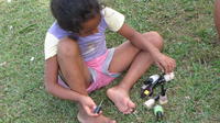 A young girl sits outside preparing to paint her nails, Panama Este, Panama