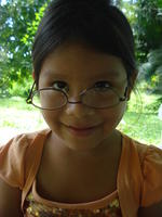 A young girl wears Rachel Teter's glasses upside down, El Plátano, Panama