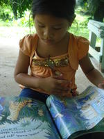 A young girl reads a children's book, El Plátano, Panama
