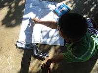 A boy does arithmetic on a large white piece of paper, El Plátano, Panama