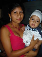 Young woman holding a baby at Rachel Teter's neighbor's quinceañera celebration in El Plátano, Panama 