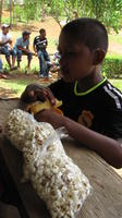 A boy eats at the concession stand during a softball game in Nueva Esperanza, Panama