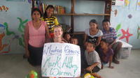 Rachel Teter and others hold a sign thanking donors for contributing to the new library, El Plátano, Panama