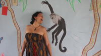 Peace Corps Volunteer Stephanie stands near the  monkey she painted in the library mural, El Plátano, Panama 