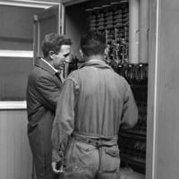Peace Corps Volunteer Charles Murray and an unidentified man working on electrical equipment at the Universidad Técnica del Estado in Temuco, Chile