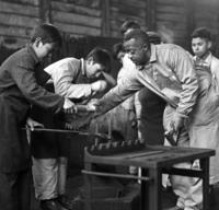 Peace Corps Volunteer Walter White instructs a forging class at the ship building school in Valdivia, Chile