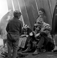 Peace Corps Volunteer Gage Skinner in traditional dress sitting with Mapuche peoples, Chile