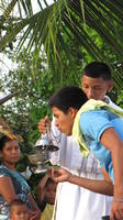 Boy blows on the thurible used in the Baptism Day service in El Plátano, Panama 