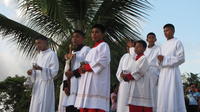 Alter boys stand with thurible and crucifix outside church on Baptism Day in El Plátano, Panama 