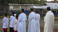Alter boys and priest walk in procession towards road on Baptism Day, El Plátano, Panama