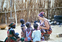 Penny Jessop teaching a woman and her children during a home visit.