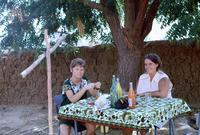 Penny Jessop eating lunch with another volunteer under a tree