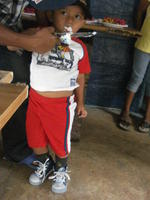 Boy eating cake from the knife at his birthday party in  El Plátano, Panama