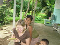 Girl poses behind Rachel Teter who is carving a totuma, or calabash gourd, El Plátano, Panama