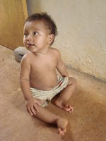 Baby sitting on a concrete floor, El Plátano, Panama