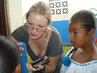 Young girl watches as Rachel Teter applies makeup to a girl for the patronage festival in El Plátano, Panama