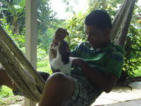 Rachel Teter's host brother plays with a cat in a hammock, El Plátano, Panama