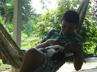 Rachel Teter's host brother sits in a hammock with a cat, El Plátano, Panama