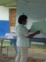 Close-up of a woman presenting her work to participants at an agribusiness workshop in El Plátano, Panama