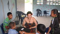 Peace Corps Volunteer playing card games with children at the library, El Plátano, Panama