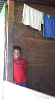 A boy smiles from a window during an agribusiness seminar in Julie's community,  Bocas del Toro, Panama