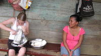 Woman watches Rachel Teter grate yuca into a bowl to make enyucado, El Plátano, Panama