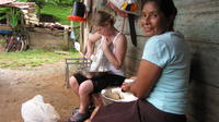 Woman sits next to Rachel Teter while she grates yuca for enyucado, El Plátano, Panama