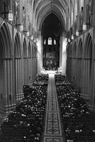 Long range view of the center aisle and congregation attending a religious service at the Washington National Cathedral (1977)