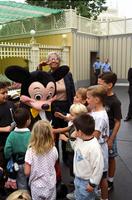 Iona Striner and children surrounding Mickey Mouse in Disneyland, Anaheim, California