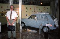 Man posing in front of "car wash" car at Yugo Next exhibition in Union Station, Washington, D.C.