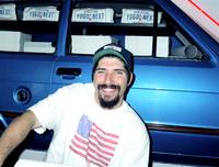 Man posing in front of Yugo Next exhibition car in Union Station, Washington, D.C.